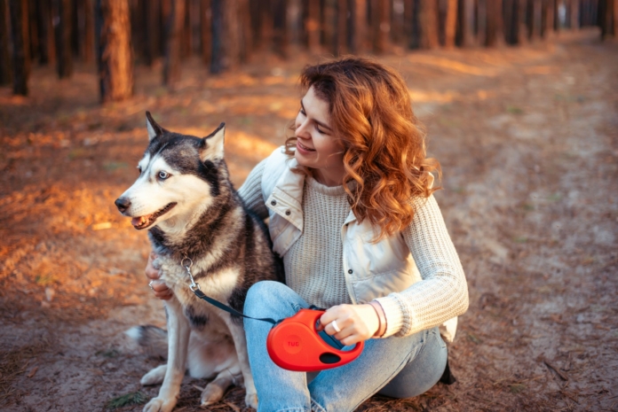 a woman sitting on the ground with a dog